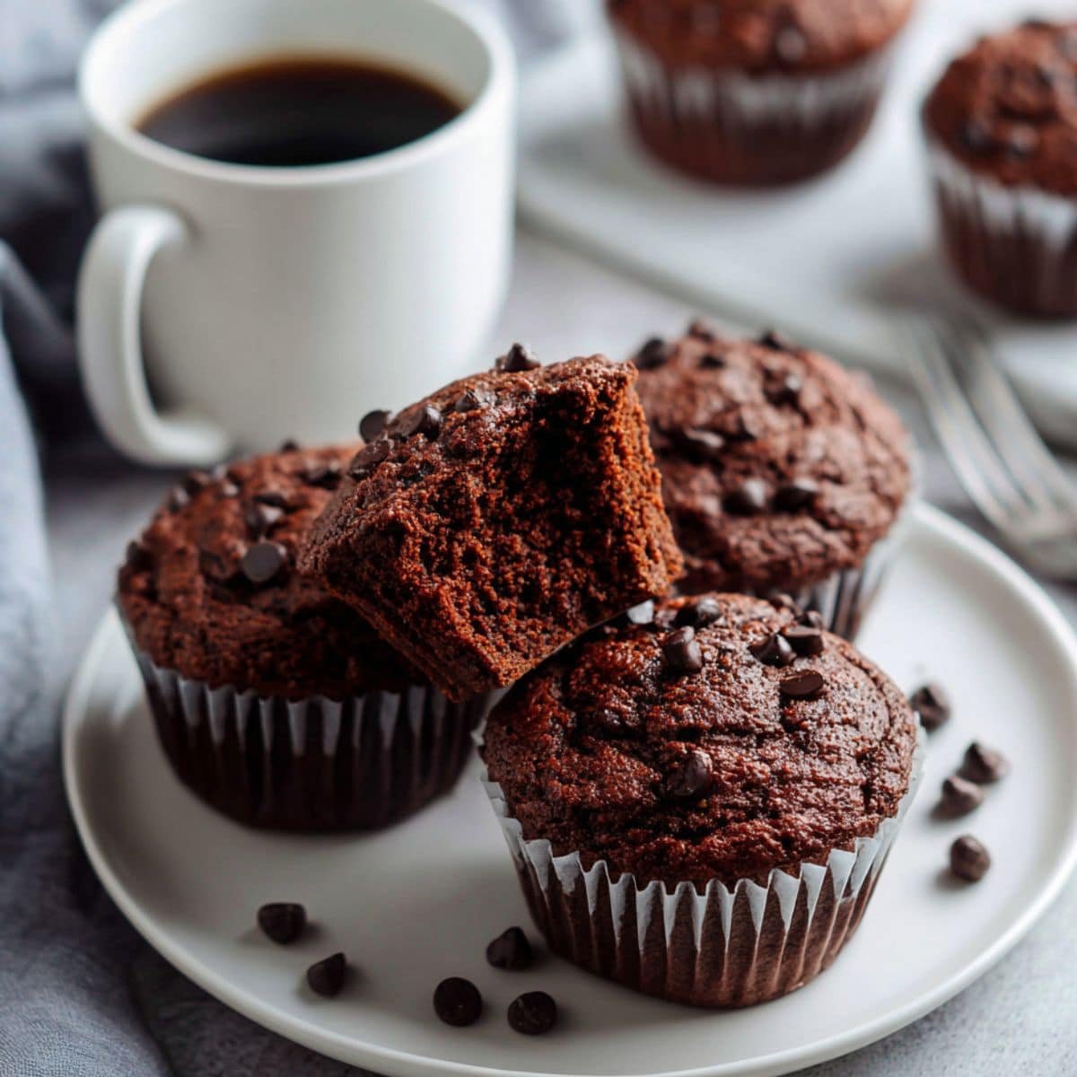 Stacked healthy chocolate muffins with a bite taken from top muffin	