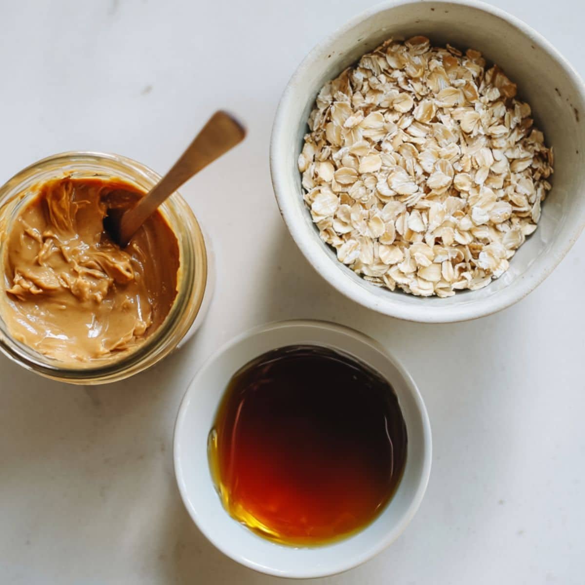 Flat lay of peanut butter, maple syrup, and oats for no bake peanut butter oatmeal cookies	