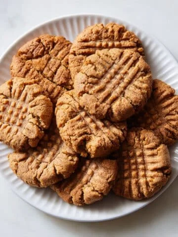 Homemade keto peanut butter cookies stacked on a white kitchen counter