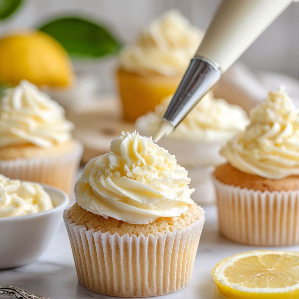 Homemade lemon cupcakes being frosted with buttercream