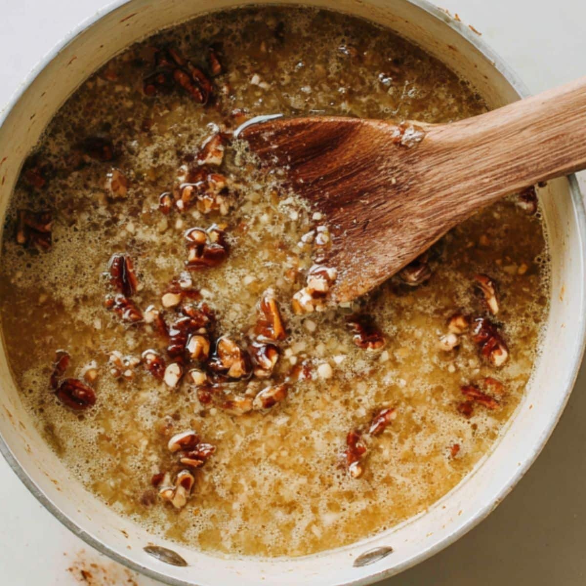 coconut pecan topping cooking in a saucepan on white counter