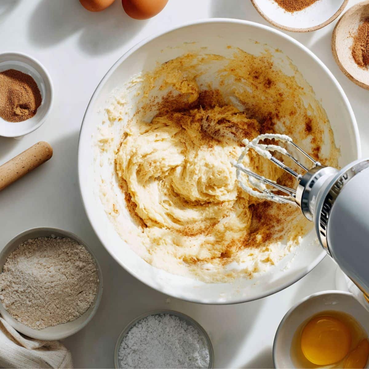 Mixing honey bun cake batter in a white bowl	