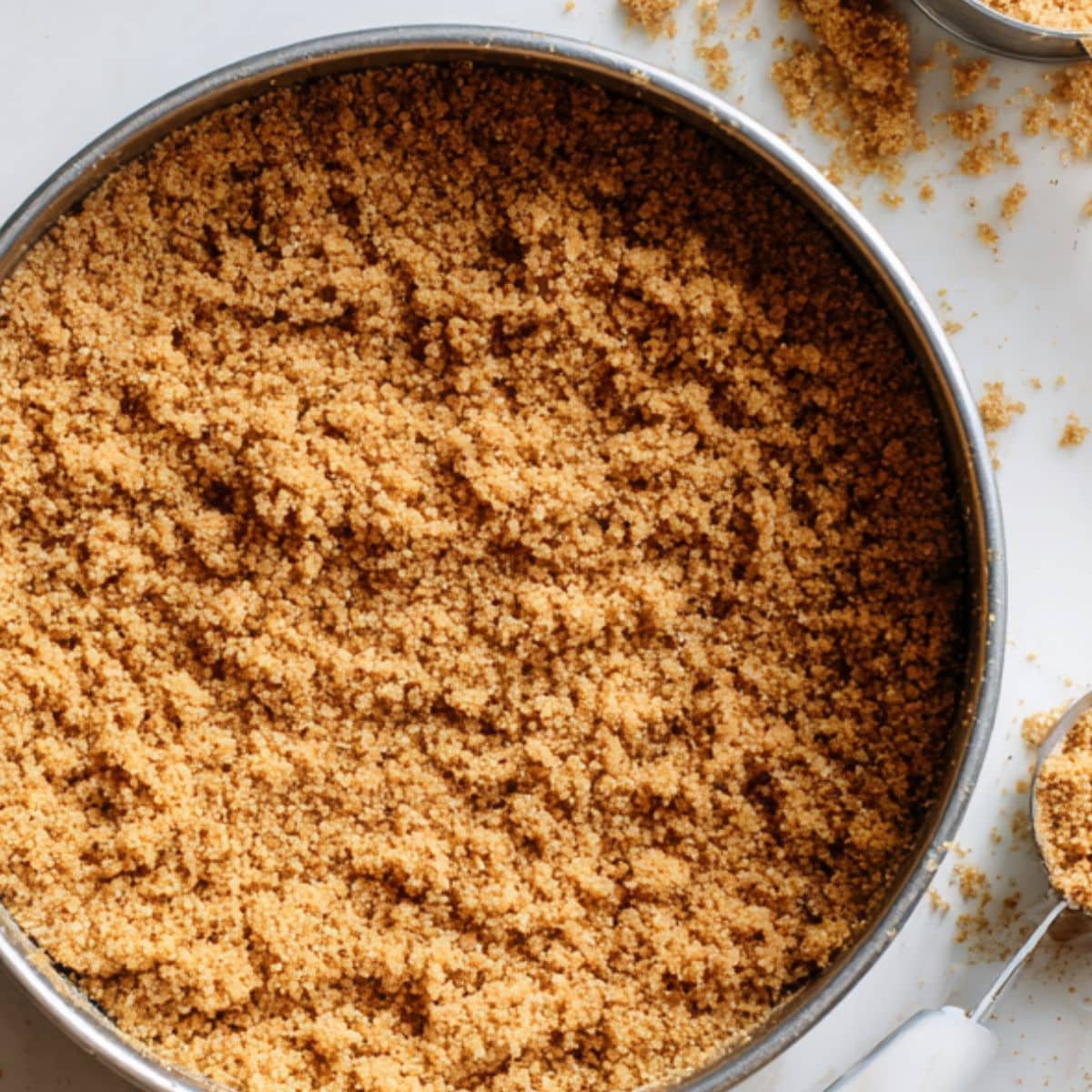 Pressing graham cracker crust into springform pan	