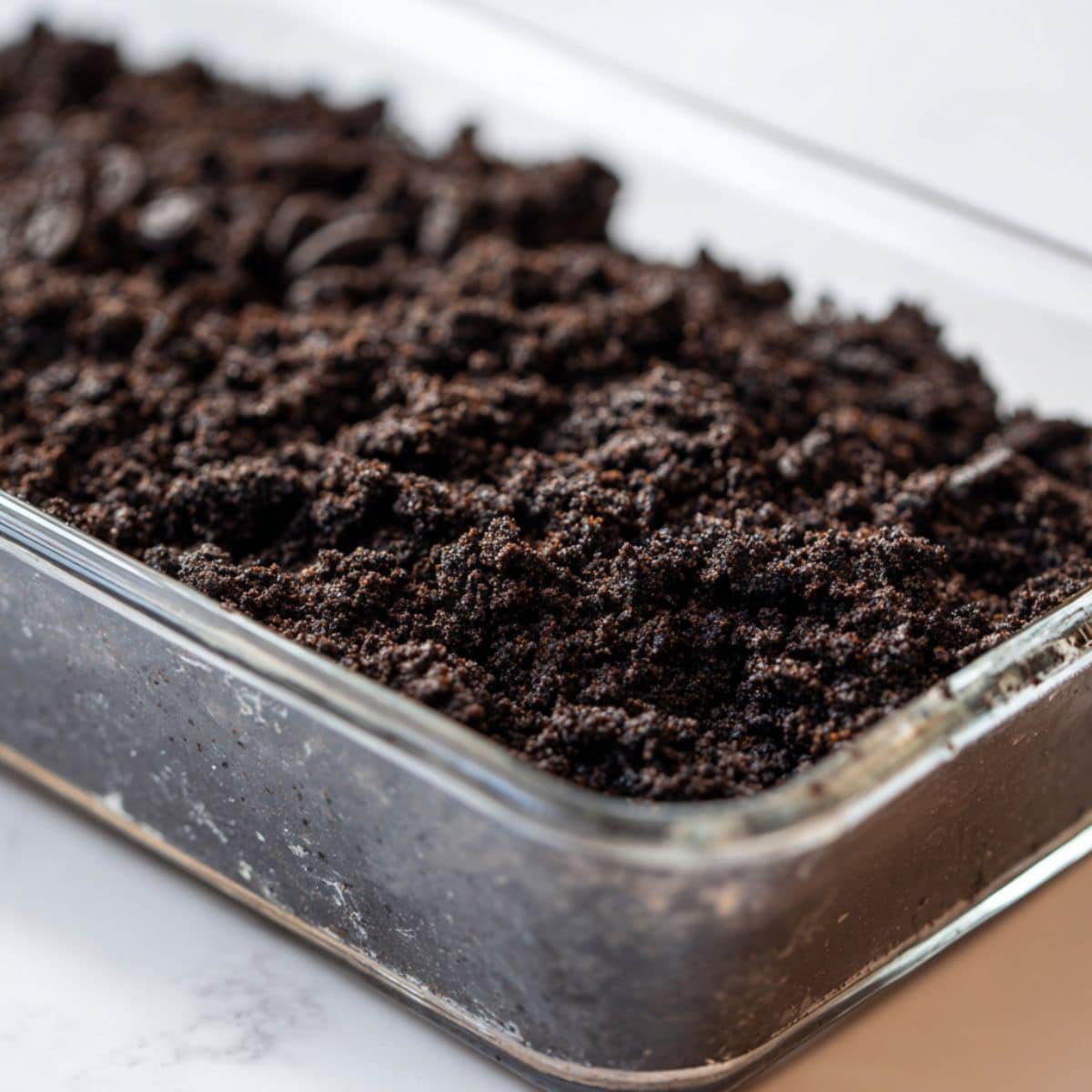 Pressing Oreo crust into glass dish	