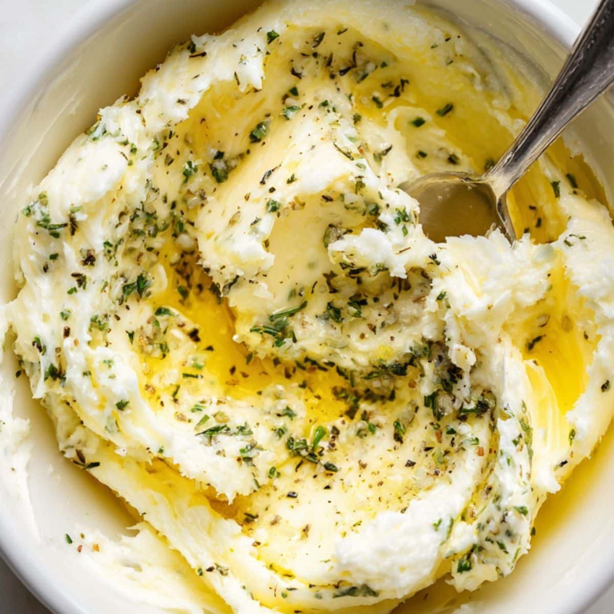 Mixing garlic butter in white bowl	