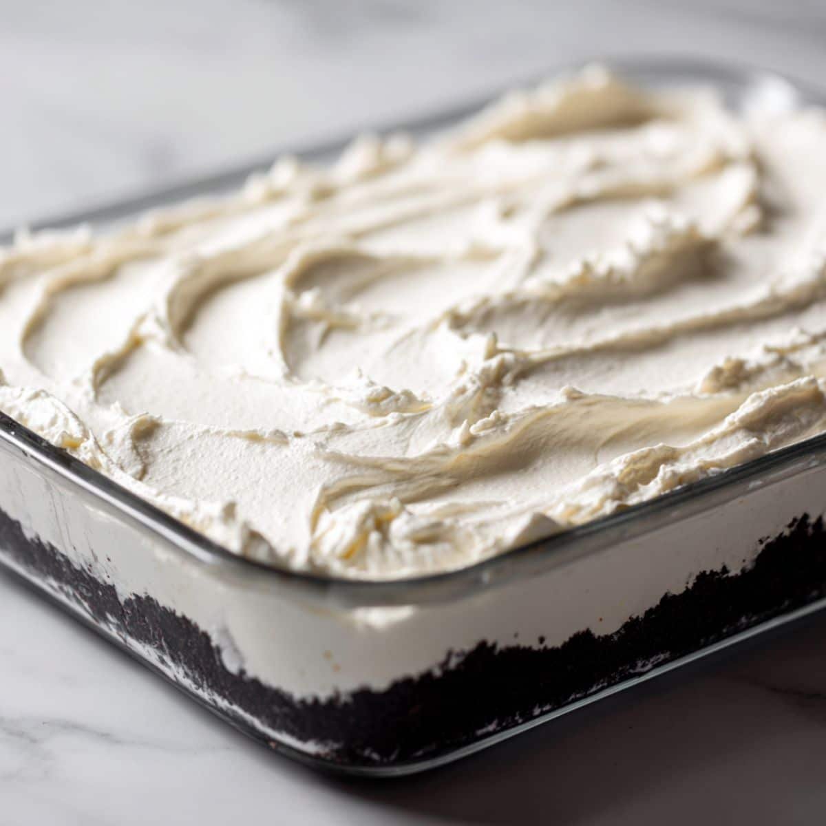 Spreading cream cheese mixture over Oreo crust	