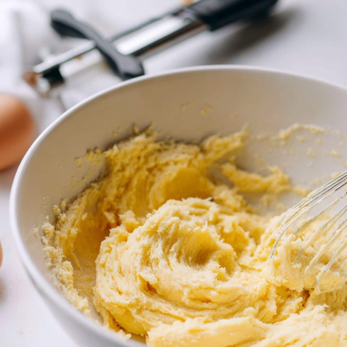 Butter, sugar, eggs being creamed in mixing bowl	