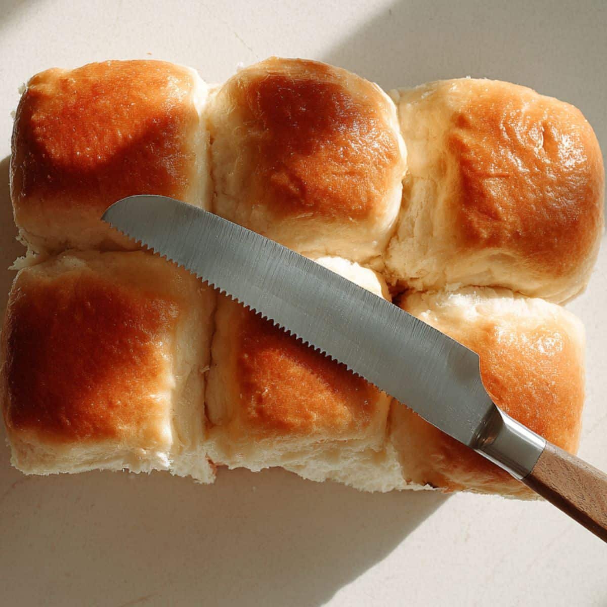 Slicing Hawaiian rolls horizontally	