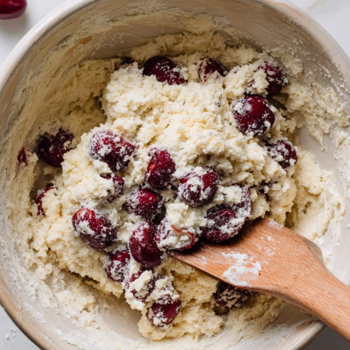 Folding cherries into the cake batter	