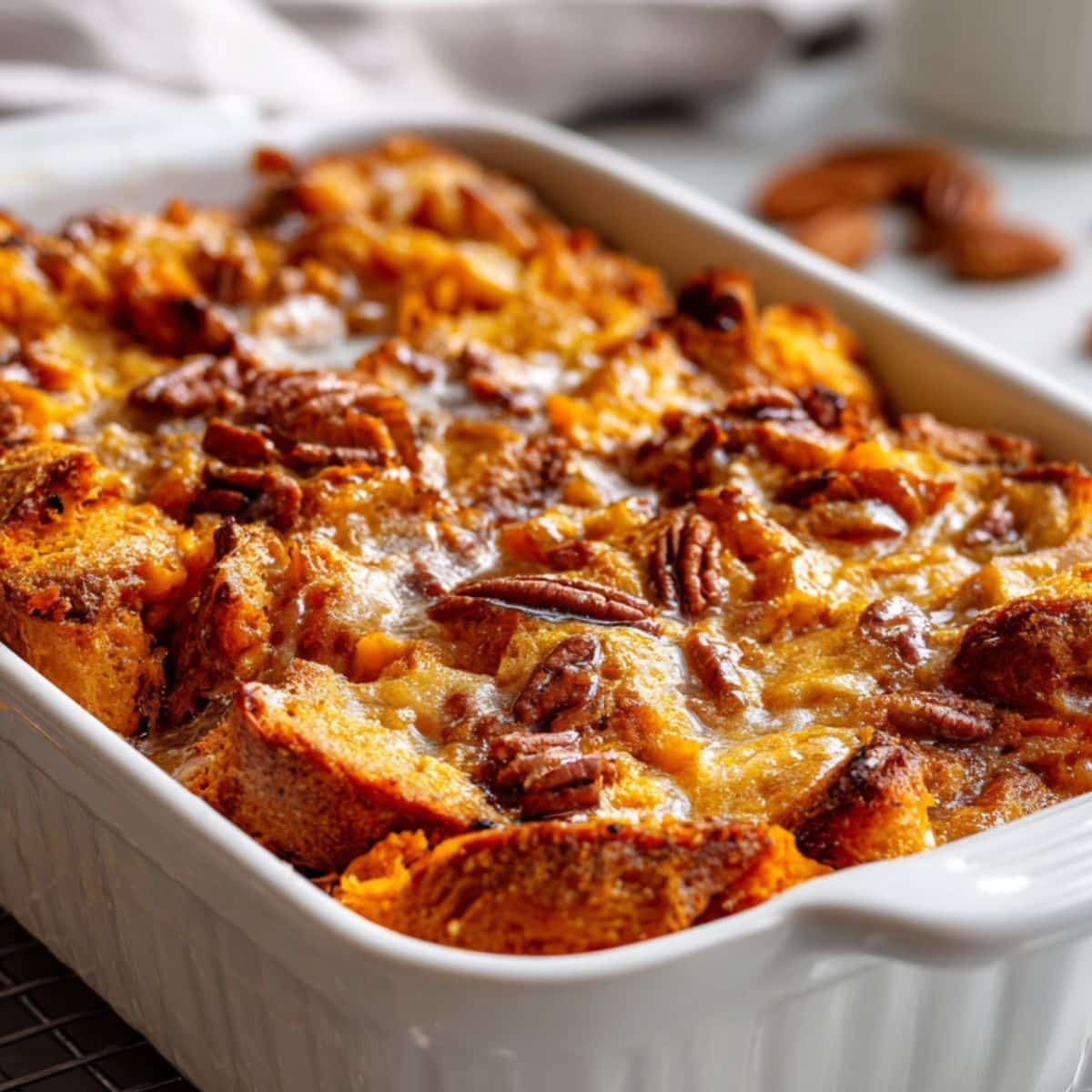 Overhead view of golden sweet-potato bread pudding cooling on a white counter	