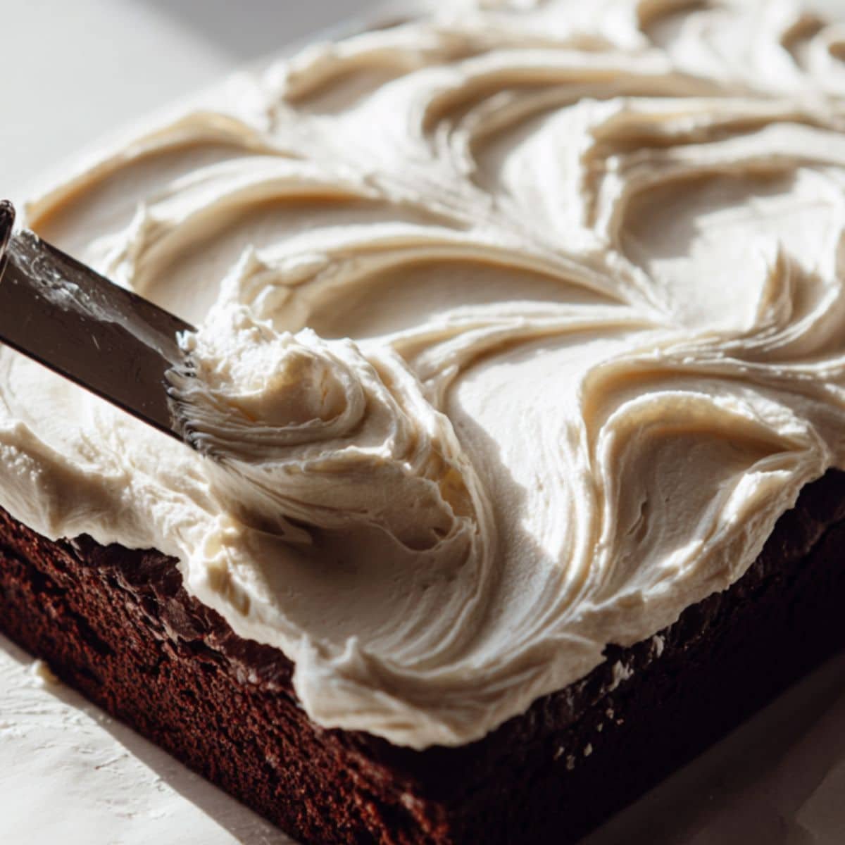Spreading mascarpone cream over brownies	