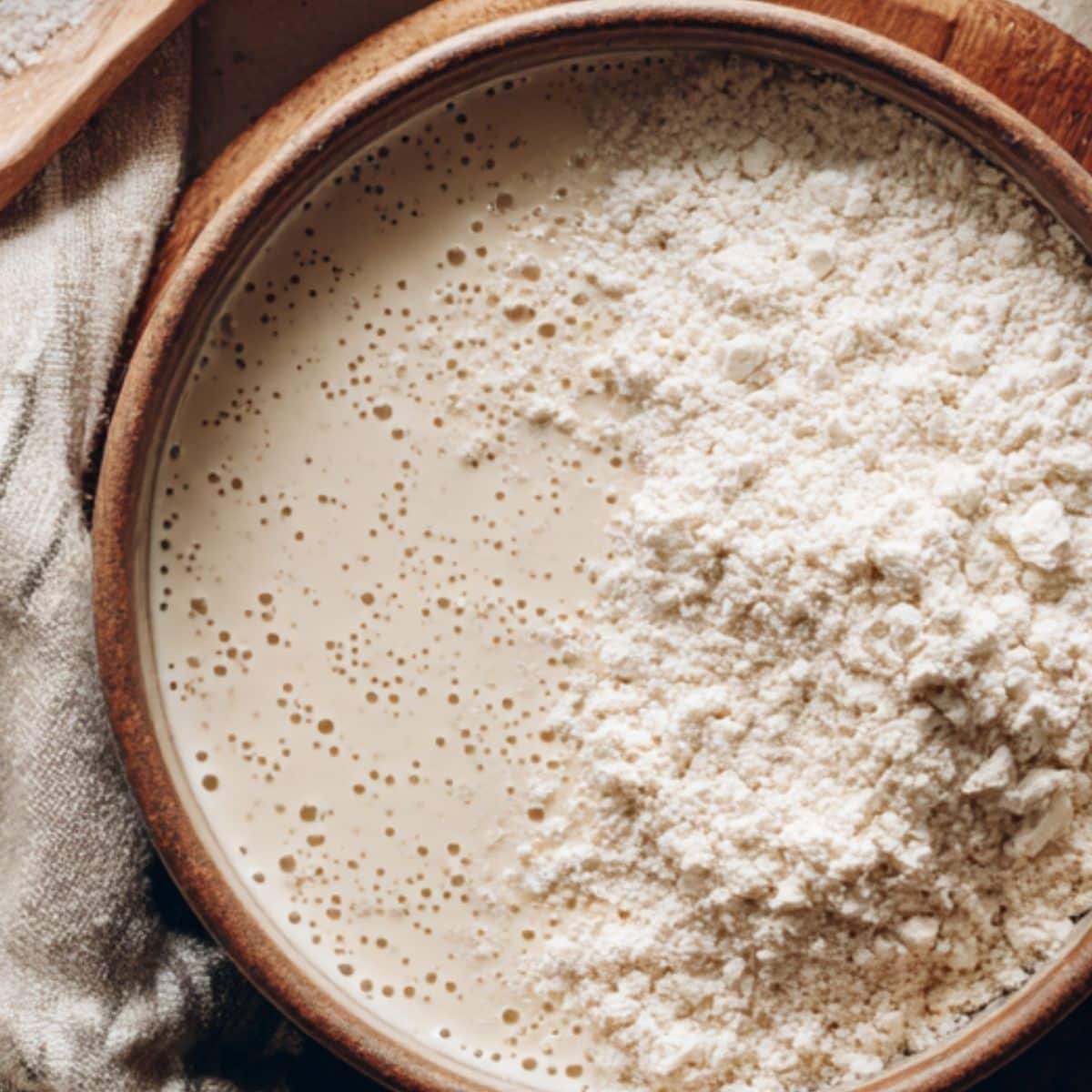 Yeast mixture activating next to dry oat flour in a mixing bowl	
