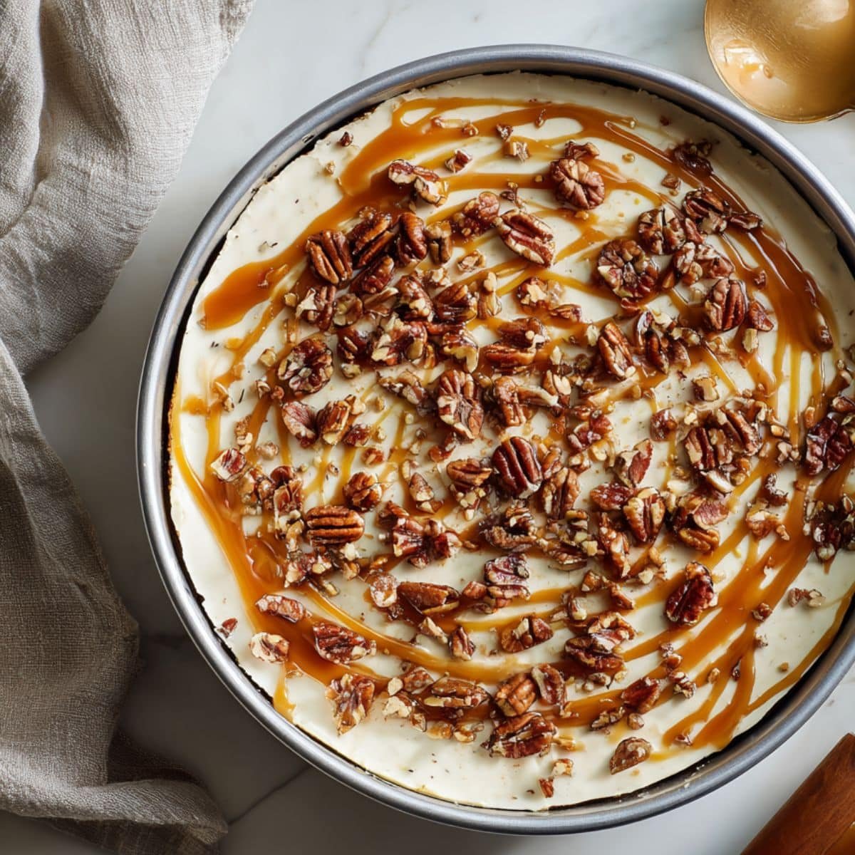 Half-assembled turtle cheesecake with caramel drizzle