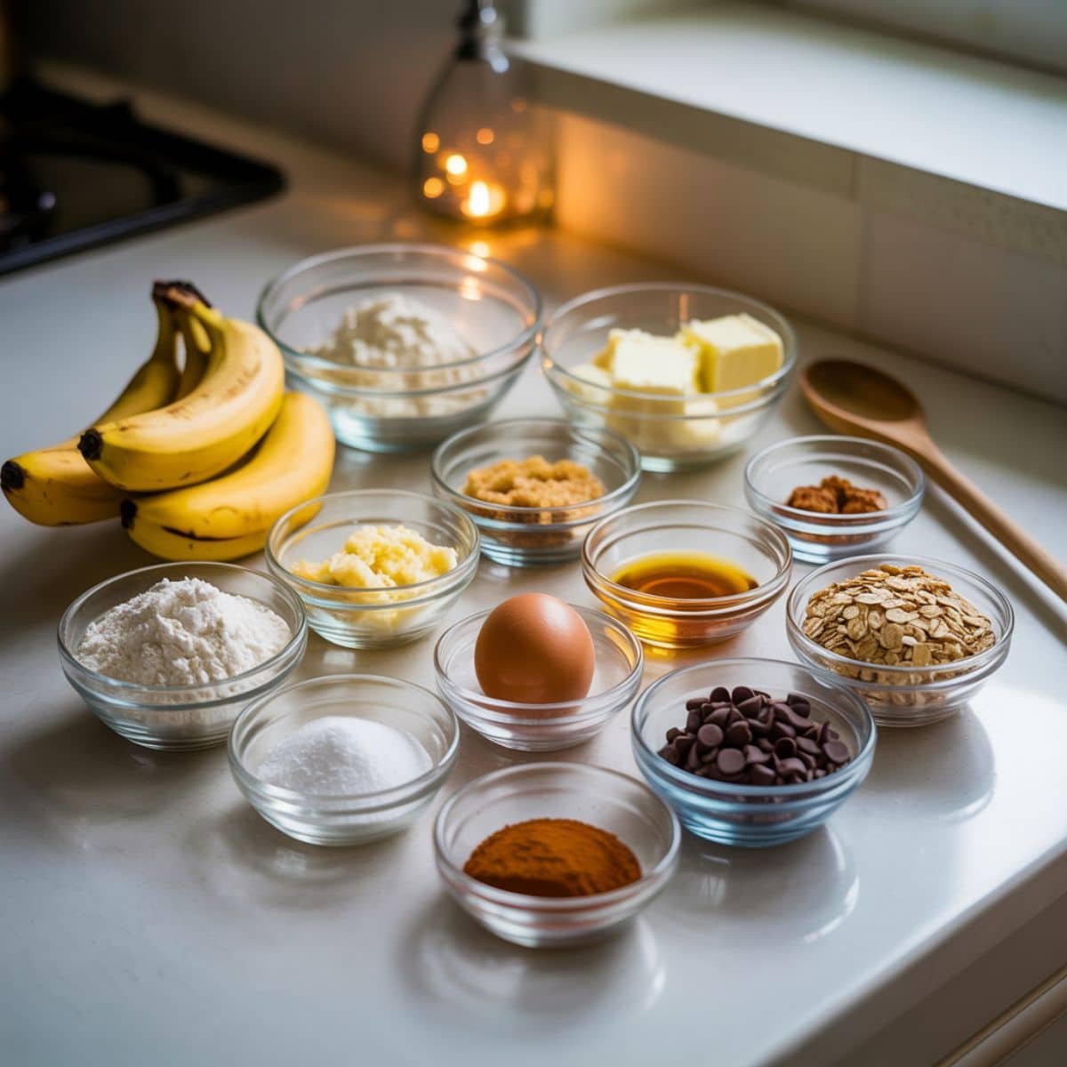 Flat lay of measured ingredients for banana chocolate cookies on white kitchen counter