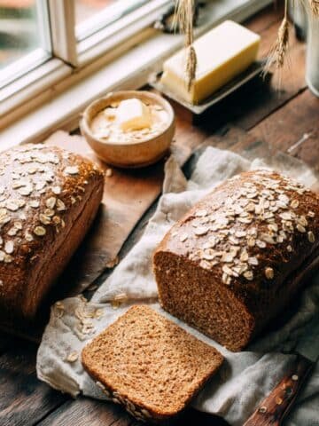 Freshly baked Cheesecake Factory-style brown bread loaves, sliced and topped with oats