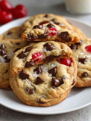 Freshly baked chocolate cherry cookies with melted chocolate chips and cherries top-down on white kitchen counter