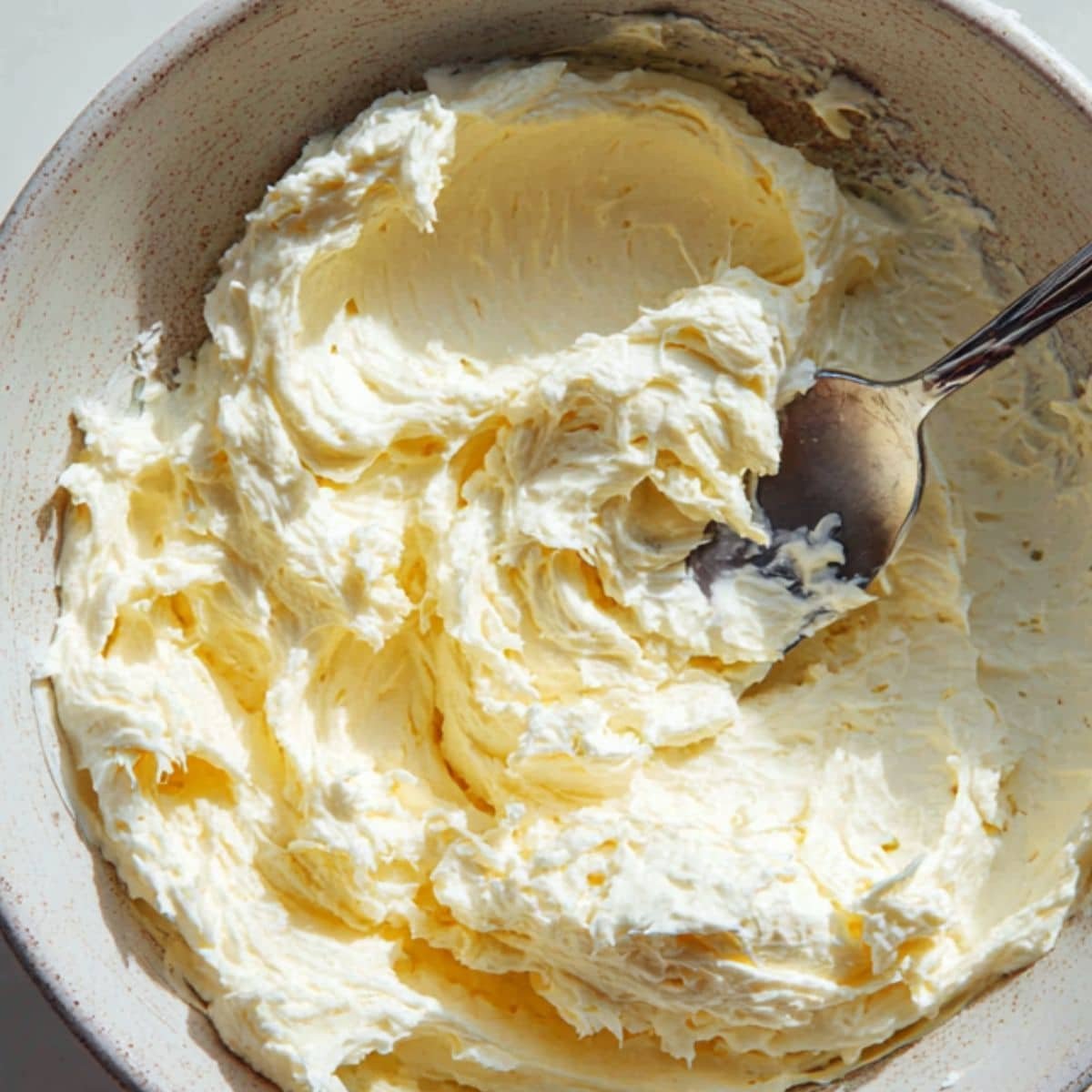 Cream cheese filling in a bowl with spoon