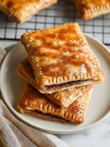 Freshly baked brown sugar pop tarts with cinnamon glaze on plate