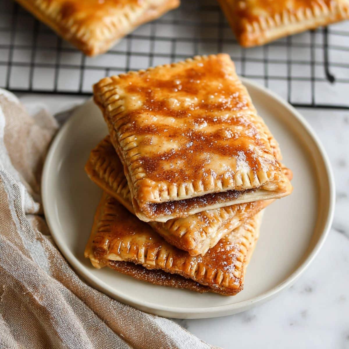 Freshly baked brown sugar pop tarts with cinnamon glaze on plate	