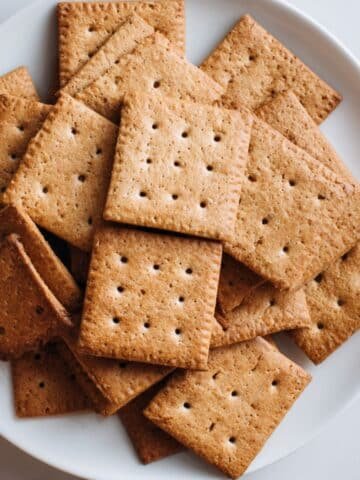 Homemade gluten free graham crackers stacked on white counter