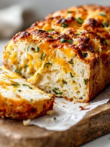 Sliced homemade jalapeño cheese bread with melted cheddar and golden crust