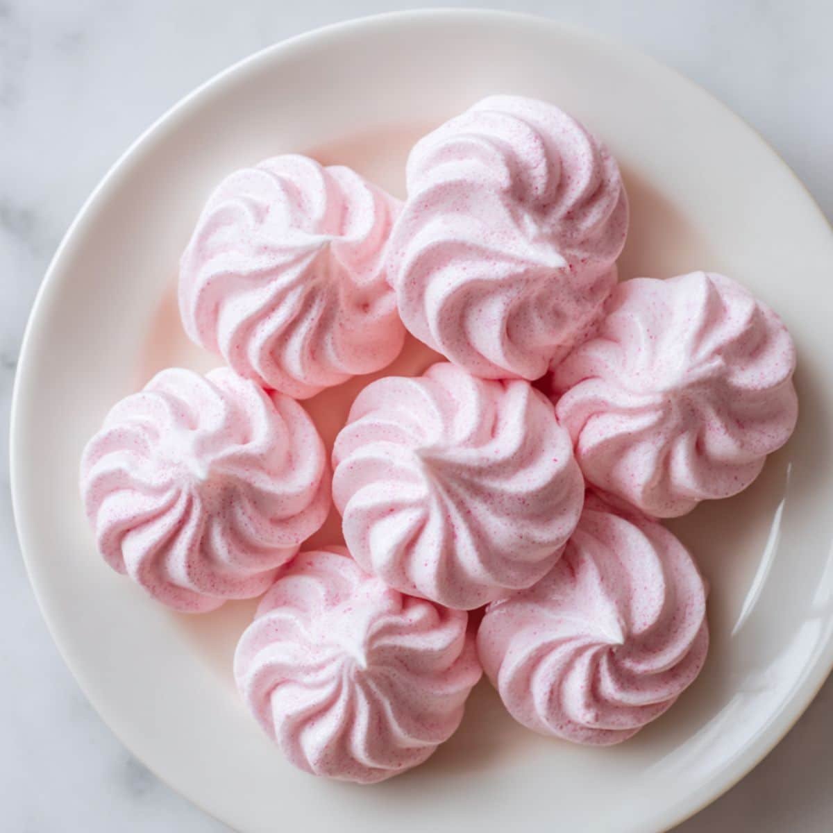 Homemade pink meringue cookies on plate	