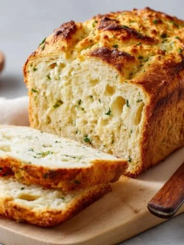Freshly baked loaf of homemade cottage cheese bread on wooden board