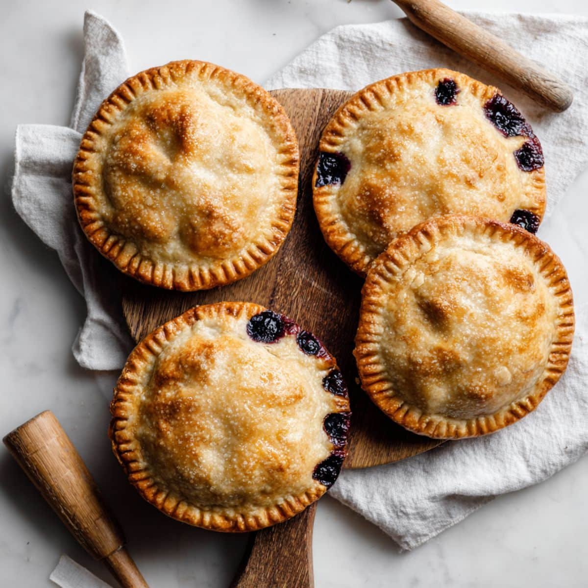 Golden homemade blueberry Hand Pies Recipe on white kitchen counter
