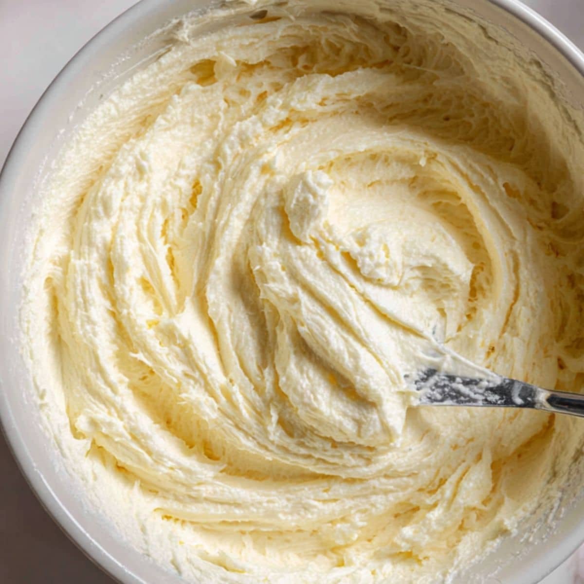 Creamy cheesecake filling in mixing bowl