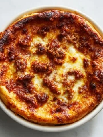 Homemade Pizza Pot Pie Recipe with melted cheese and marinara sauce in a white bowl