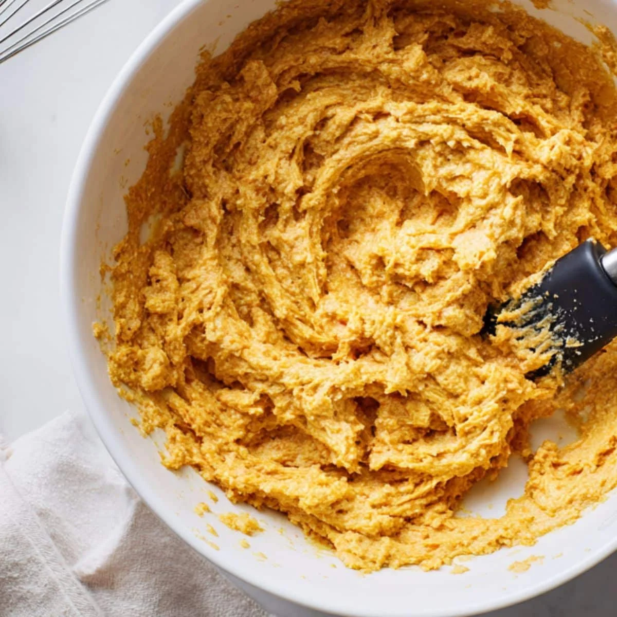 Mixing pumpkin muffin batter in a bowl