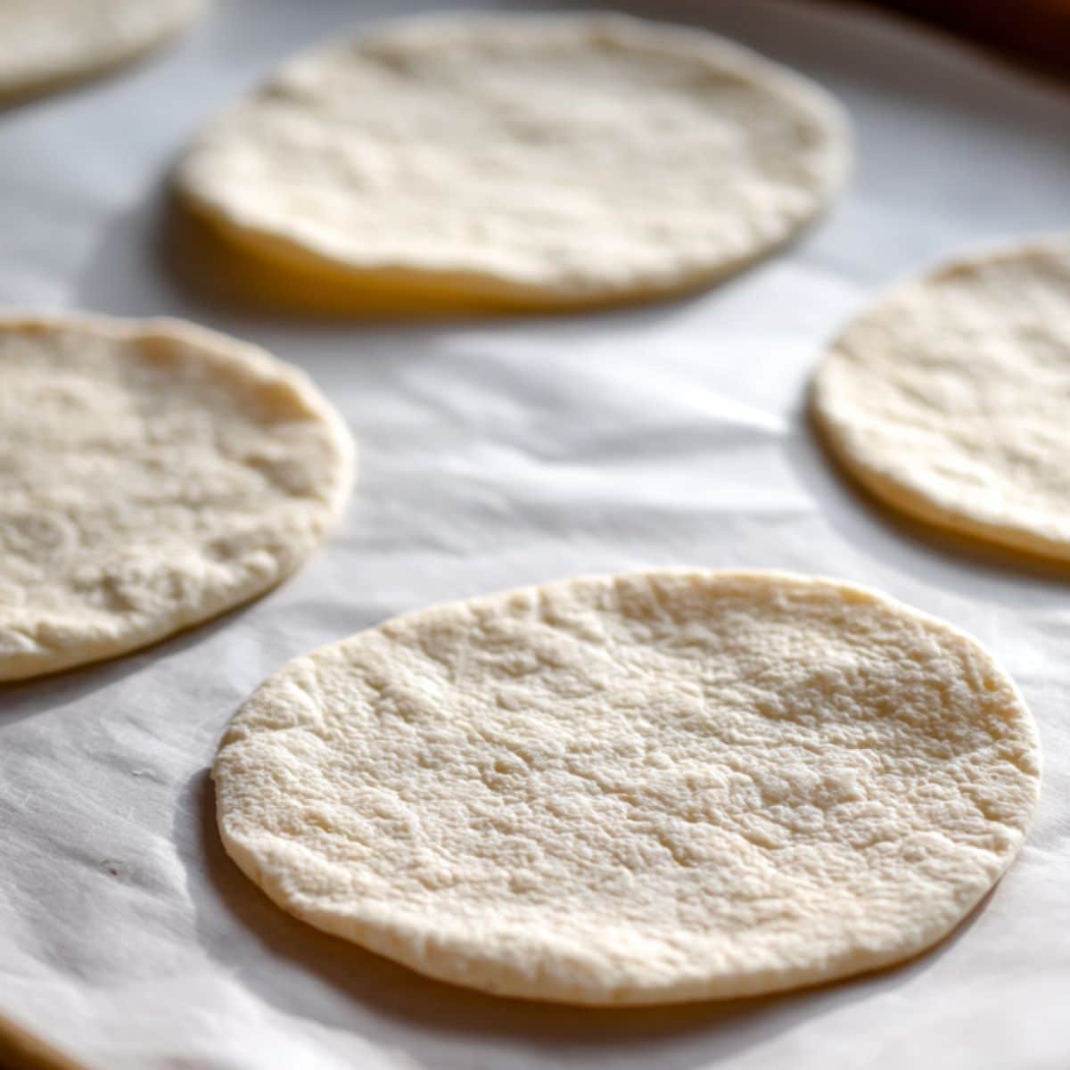 Rolled pita rounds resting before baking