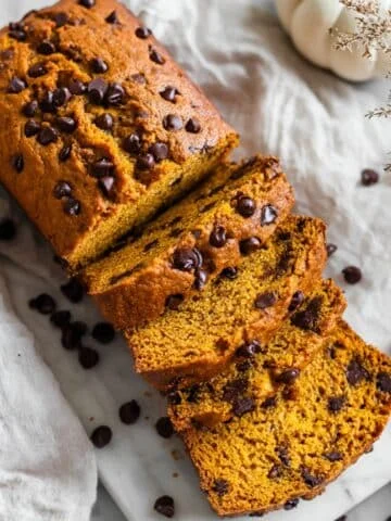 Sliced pumpkin chocolate chip bread with melty chips on marble top
