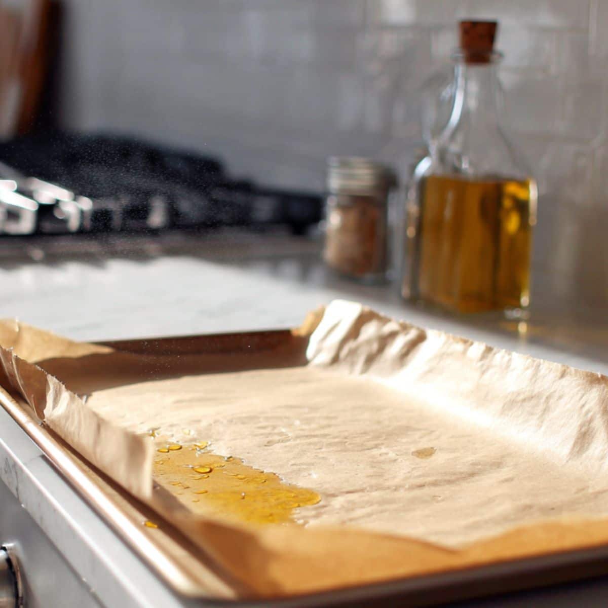 Lining a sheet pan with parchment paper and spraying it with oil