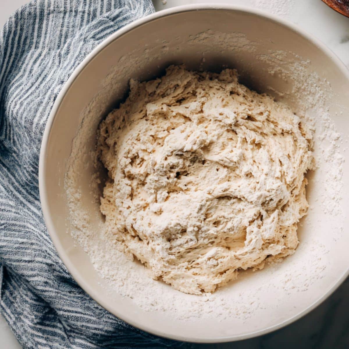 Mixing sourdough starter, flour, and water into shaggy dough