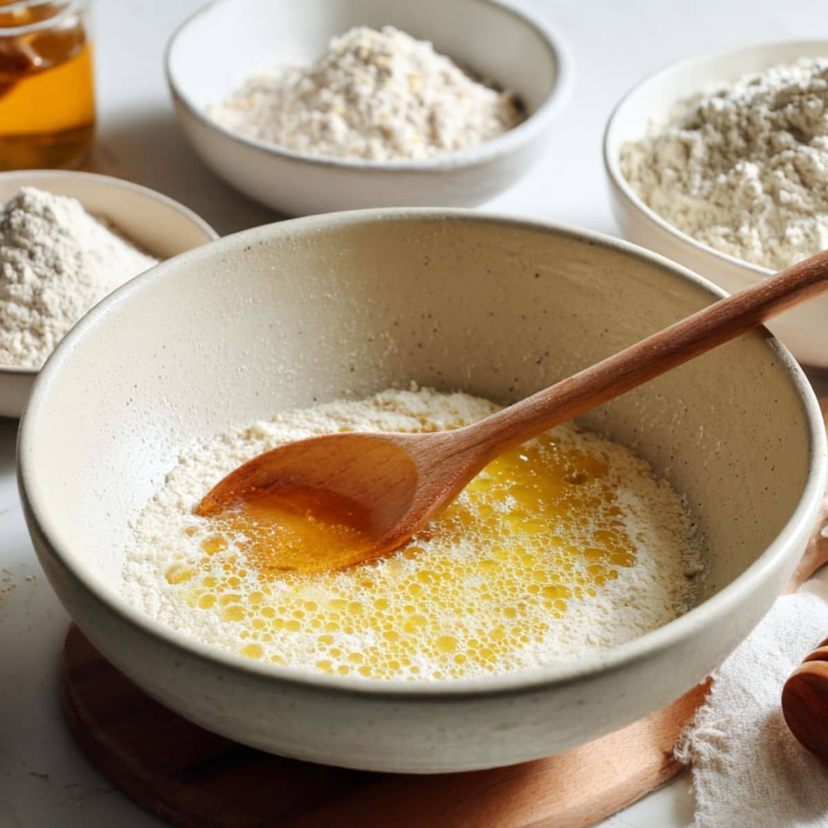 Mixing yeast and honey with warm water in a large bowl	