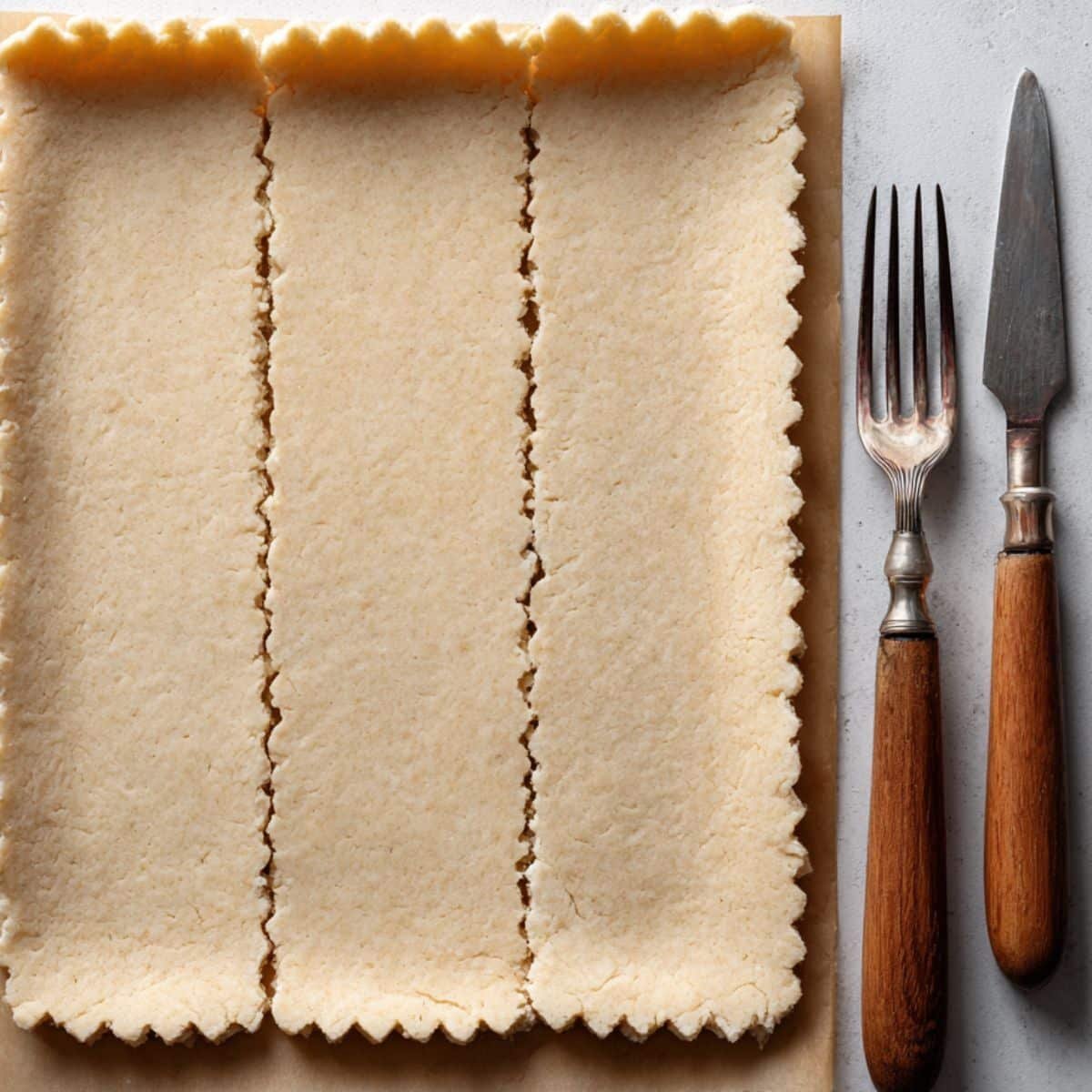 Rolled dough cut into rectangular graham crackers with fork marks