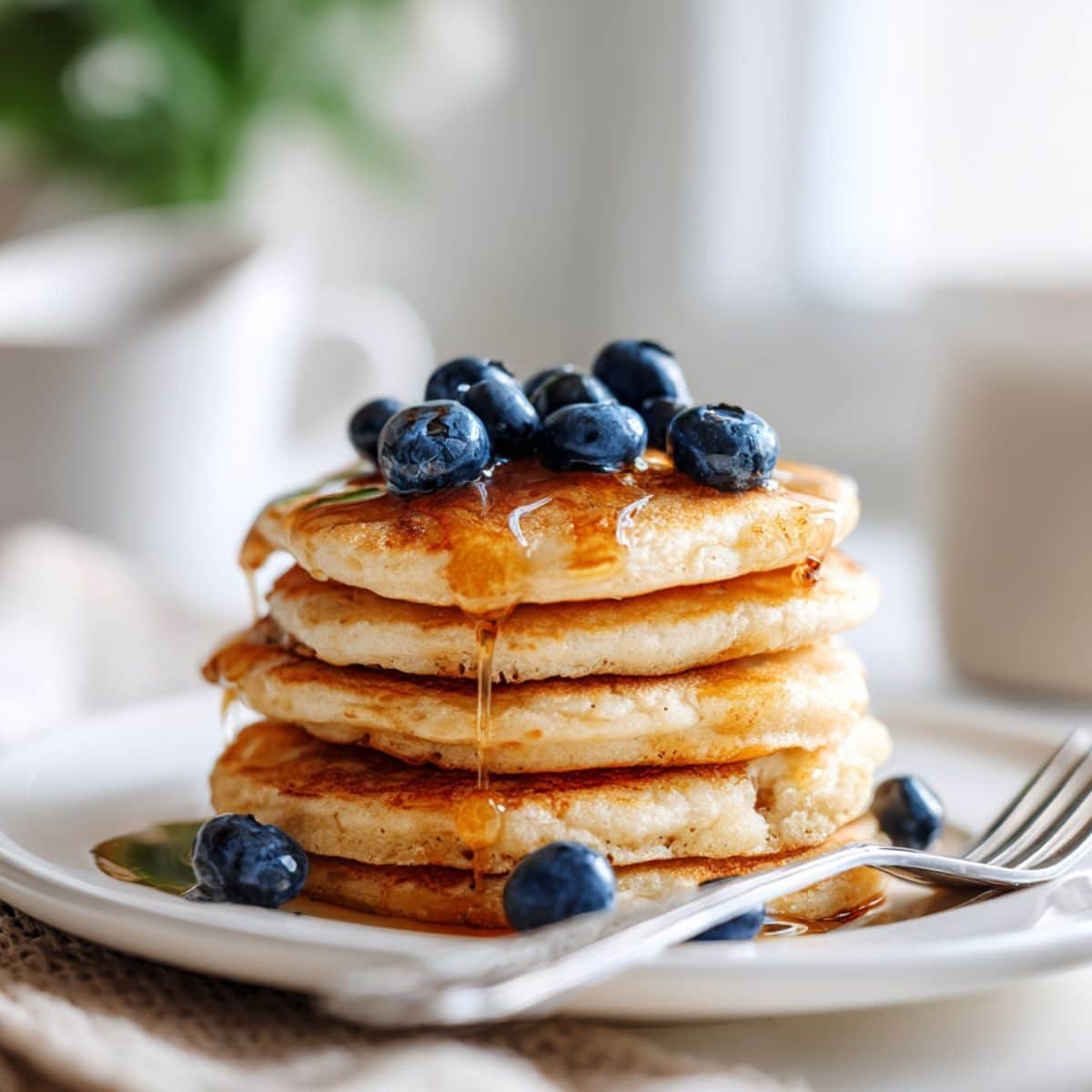 Serving stack of cottage cheese protein pancakes with blueberries and syrup