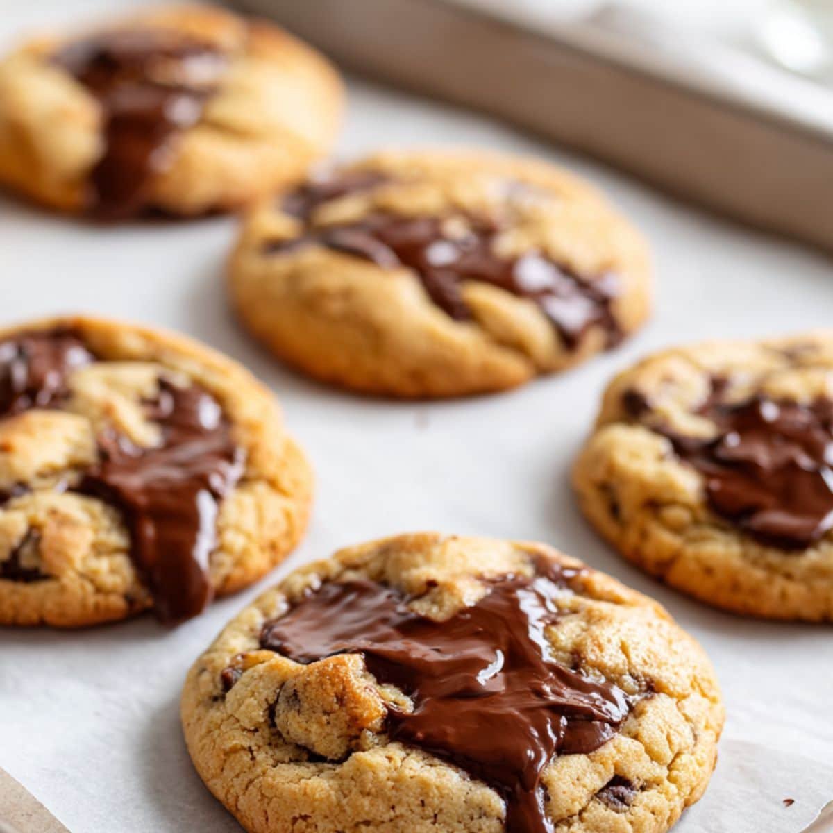 Cookie dough balls stuffed with Nutella on a parchment-lined baking sheet