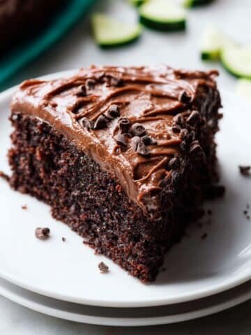 Moist zucchini chocolate cake with rich chocolate frosting on a white kitchen counter