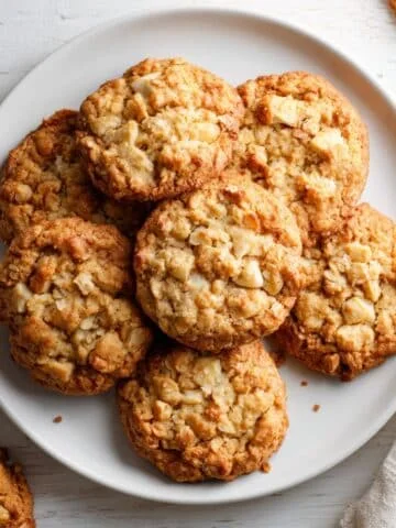 Soft and chewy homemade apple cookies cooling on a wire rack, photographed from above on a white kitchen table.