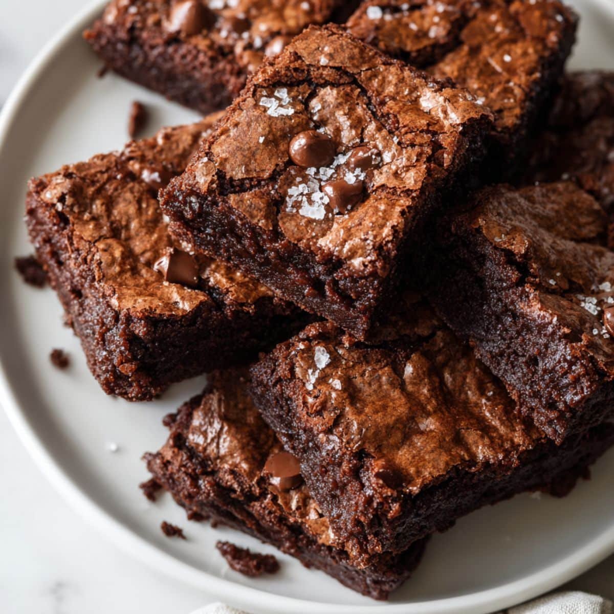 Homemade cake mix brownies cut into squares on a white kitchen table with crumbs scattered, shot from above.
