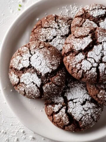 Homemade chocolate mint cookies dusted with powdered sugar on a white kitchen table
