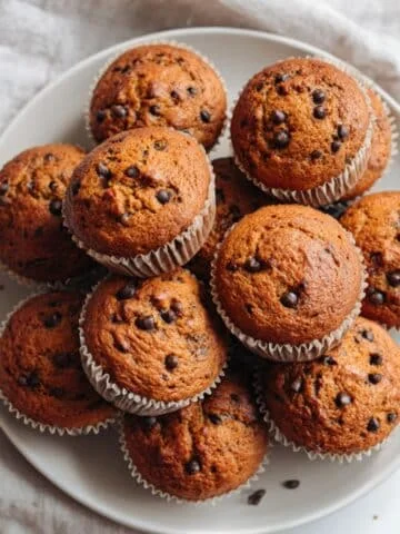 Freshly baked healthy pumpkin muffins cooling on a rack, rustic and homemade style.