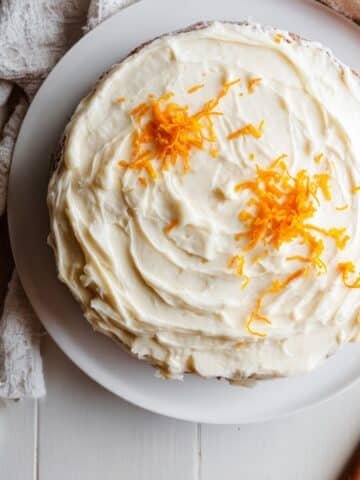 Homemade mandarin orange cake recipe with cream cheese frosting, photographed from above on a white kitchen table