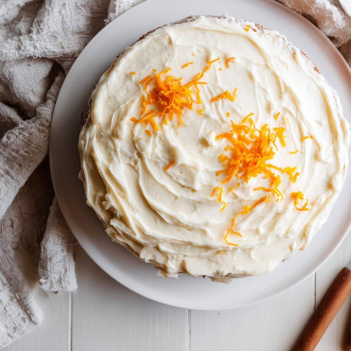 Homemade mandarin orange cake recipe with cream cheese frosting, photographed from above on a white kitchen table