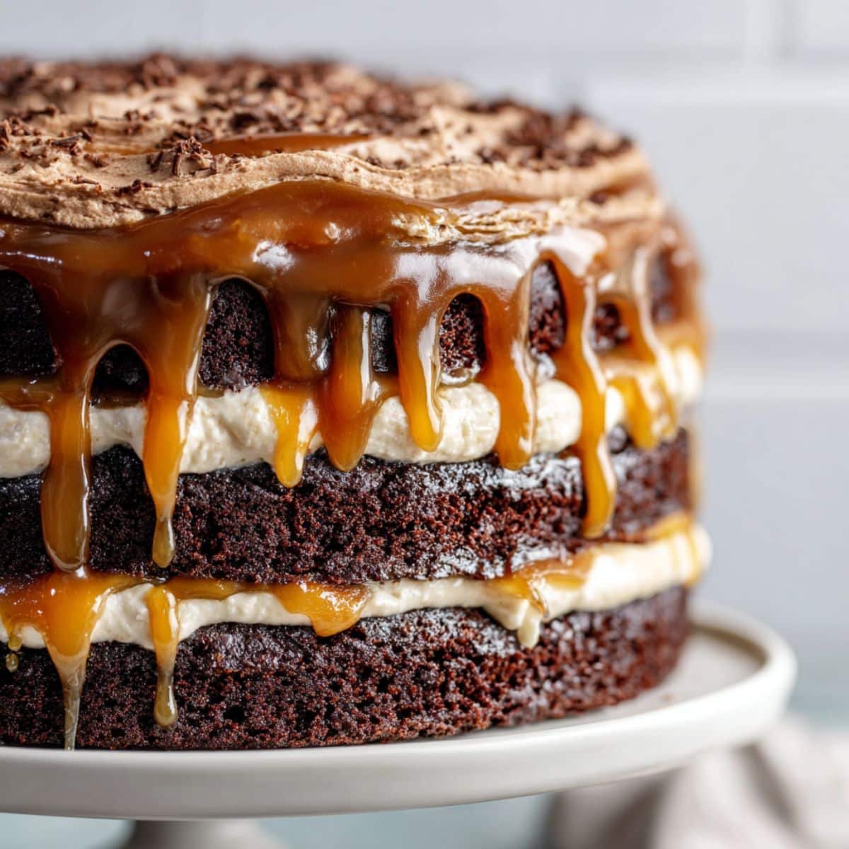 Chocolate caramel cake with gooey caramel filling and rich frosting on a white kitchen counter