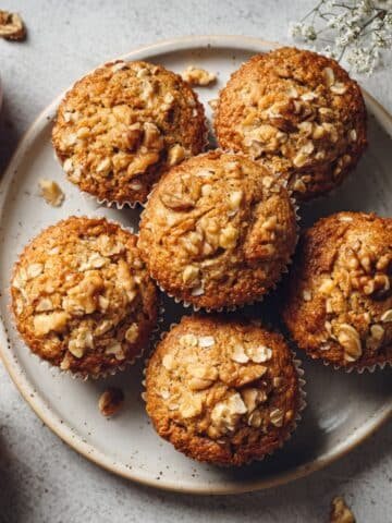Freshly baked healthy apple muffins on a white kitchen table, top-down homemade style photo with natural light