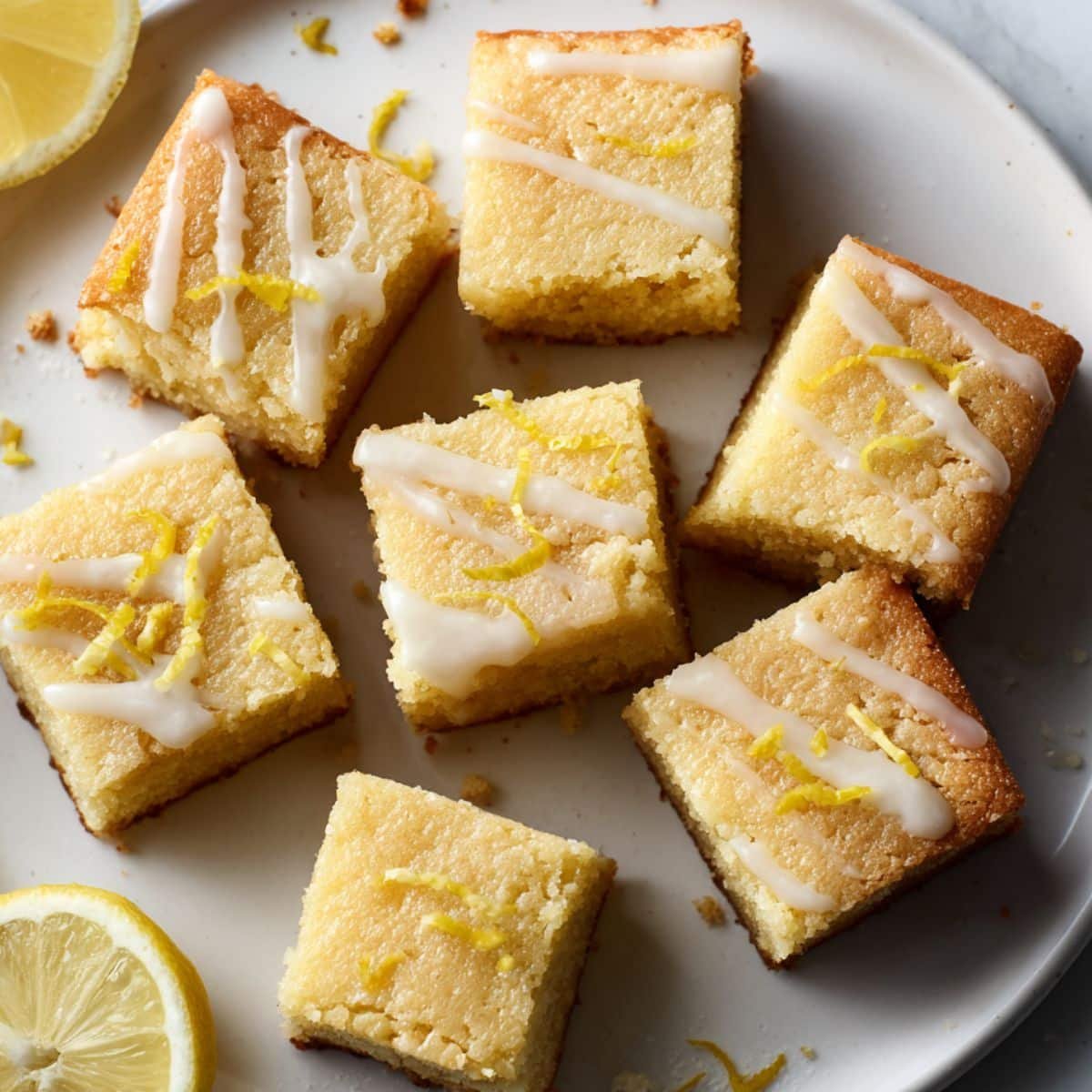 Fudgy Lemon Brownies Recipe cut into squares with lemon glaze on white kitchen counter