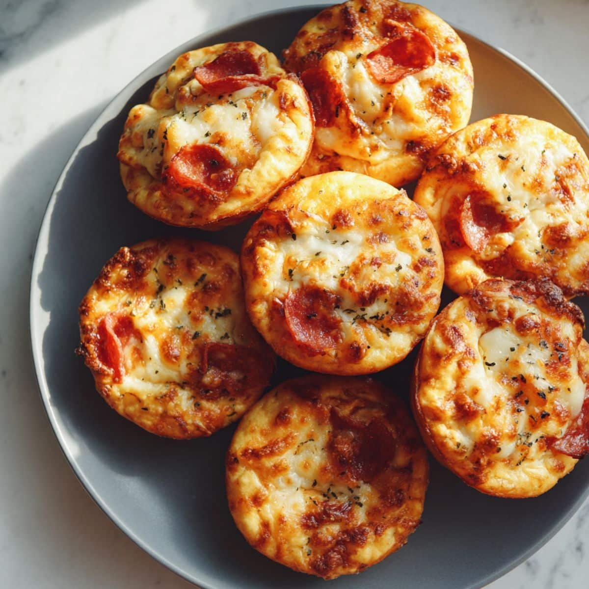 Easy 15-minute pizza muffins recipe with cheese and pepperoni served in muffin tin